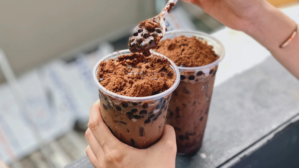 Một ly Milo đã pha với nước hoặc sữa không đường, bên cạnh gói Milo bột nguyên chất để minh họa cách pha chế lành mạnh giúp kiểm soát calo.